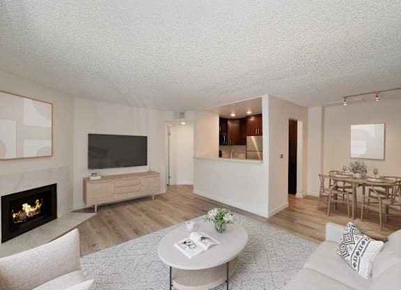 a living room with a fireplace and a dining room in the background at Croft Plaza Apartments, West Hollywood, CA 90069