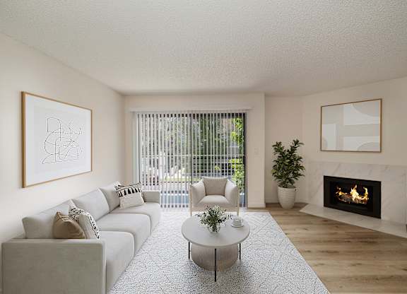a living room with a white couch and coffee table in front of a fireplace at Croft Plaza Apartments, West Hollywood