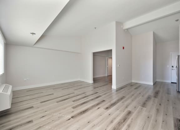 a renovated living room with hardwood floors and white walls  at Track 281 Apartments, Sacramento, CA, 95811