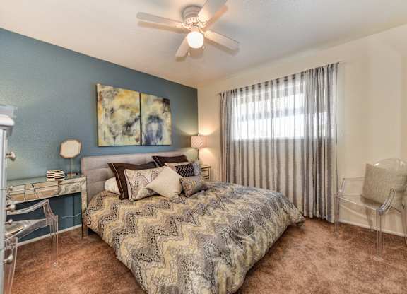 Olympus Park model home bedroom with carpet, window and ceiling fan.
