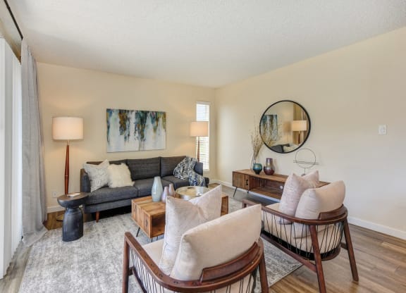 Living room with two tone paint,  Hardwood Inspired Floor, Gray/White Rug, Gray Sofa and Round Mirror  at Silverstone Apartments, Davis, CA