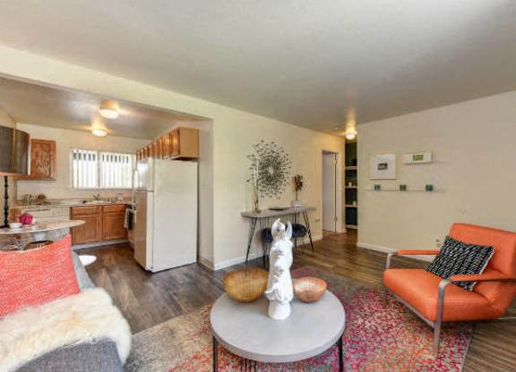 Living Room with Hardwood Inspired Floors, Orange Chairs and Table at Olympus Park Apartments, Roseville, 95661