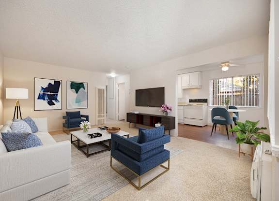 A living room with a white couch, a blue chair, and a television.