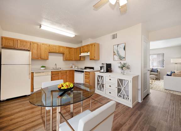 A modern kitchen with wooden cabinets and a glass table.