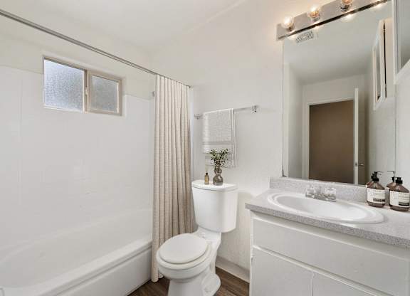 A white bathroom with a toilet, sink, and bathtub.