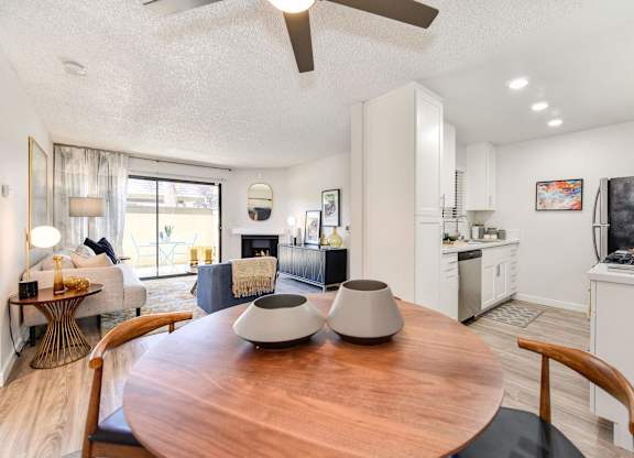A modern kitchen with a wooden table and chairs in the foreground.