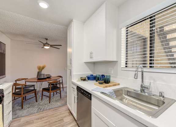 A kitchen with a table and chairs in the middle of the room.