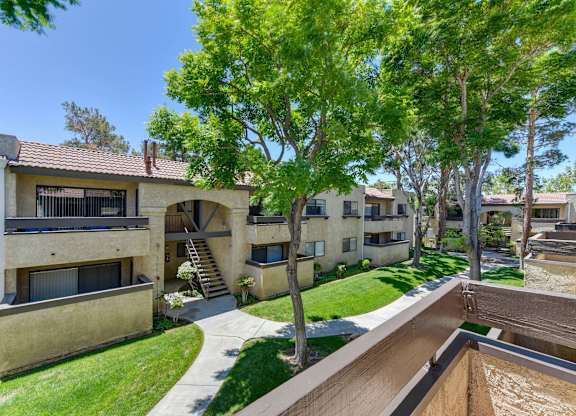 A view of a courtyard with a tree and apartment buildings.