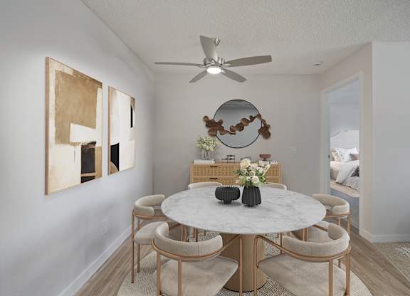 A dining room with a round table and chairs.