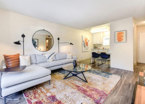 a living room with a couch table and chairs and a kitchen in the background at Renaissance Park Apartments, California