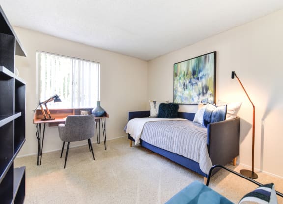 Model Home bedroom with a bed and a desk with a chair at Renaissance Park Apartments, Davis