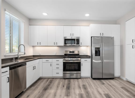 a kitchen with white cabinets and stainless steel appliances
