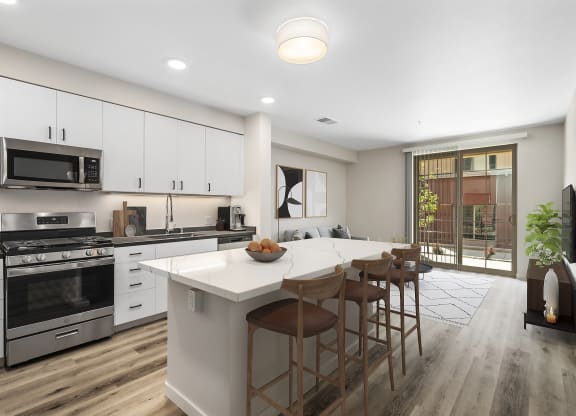 a kitchen with white cabinets and a large island with a white countertop