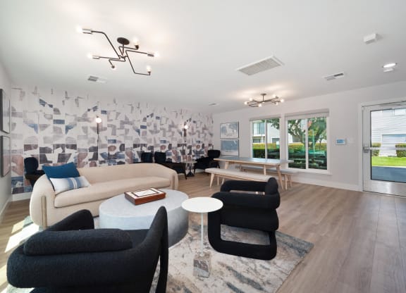 a lounge area with chairs and tables and a wall with a geo wallpaper at Silverstone Apartments, Davis, California
