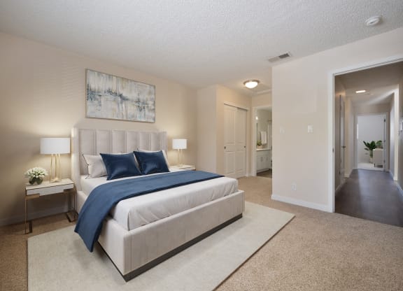 a bedroom with a white bed and blue pillows at Silverstone Apartments, Davis, California