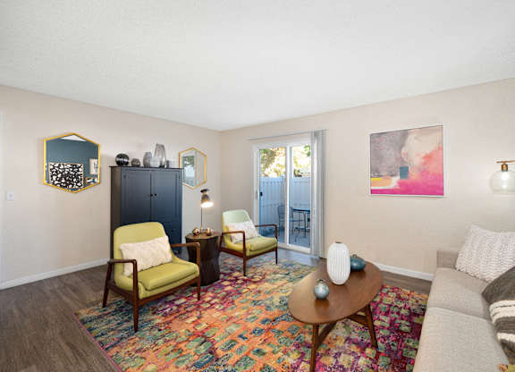a living room with a couch and chairs and a door to a balcony