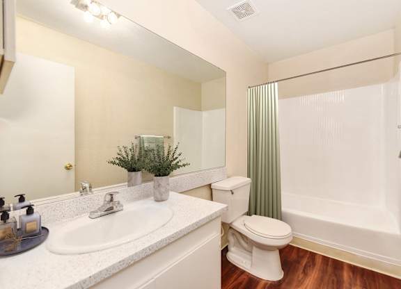 A white toilet sits next to a white sink in a bathroom.