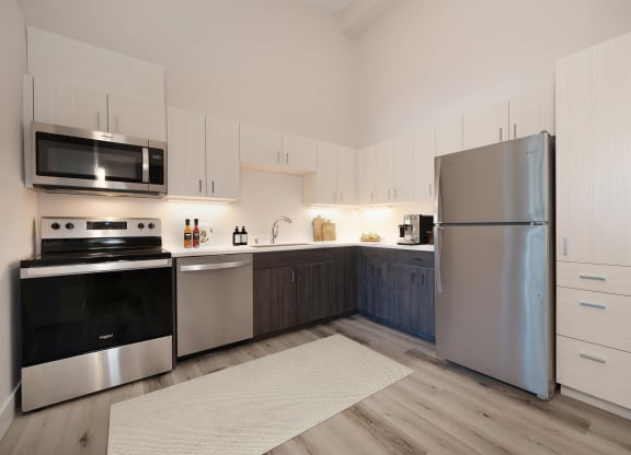 a modern kitchen with stainless steel appliances and white cabinets  at Track 281 Apartments, Sacramento, CA, 95811