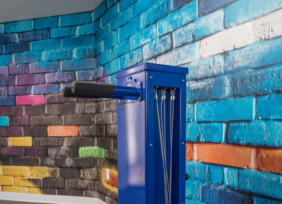 a blue metal elevator in front of a brick wall