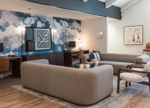 a living room with couches chairs and a desk in a hotel room