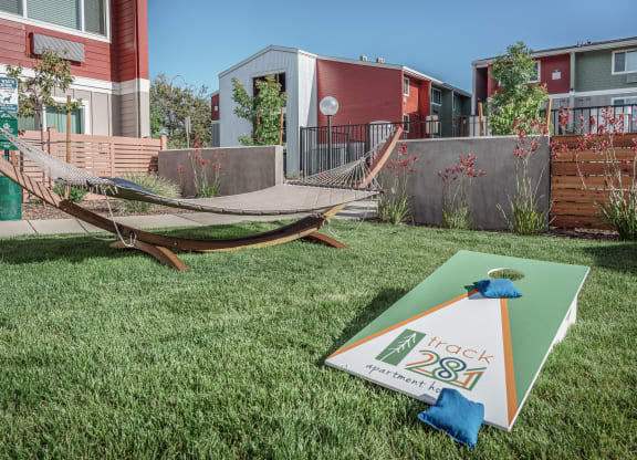 a yard with a hammock and a sign in the grass