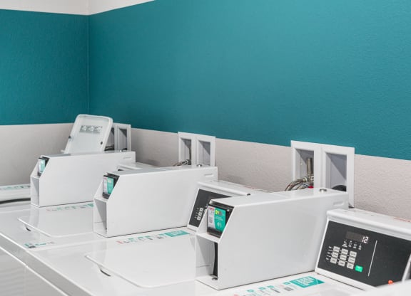 a row of white microwaves in a room with a blue wall