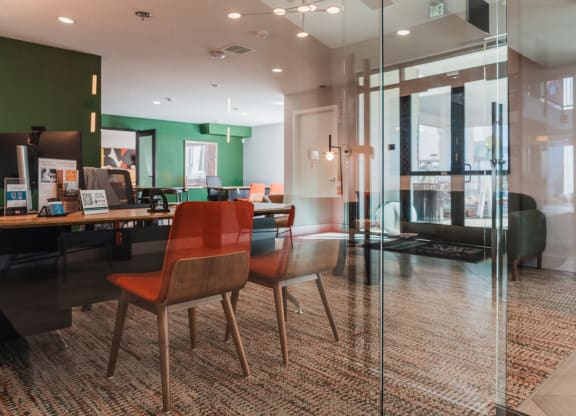a conference room with glass walls and a table with chairs