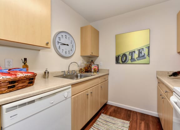 kitchen with hardwood inspired flooring, white kitchen appliances, and cabinetry at Vineyard Terrace Apartments, California 94558