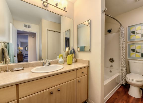 Model bathroom with long sink vanity counters, one sink, tub/shower enclosure and toilet at Vineyard Terrace Apartments, California 94558