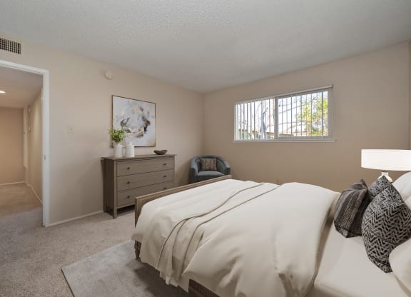 a bedroom with a bed and a dresser and a window
