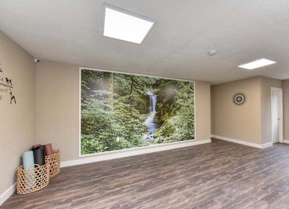 Community Yoga Studio with Hardwood Inspired Floor, Ceiling Lights, Large Window and Wicker Basket with Yoga Mats at Fountains of Fair Oaks, Fair Oaks, CA