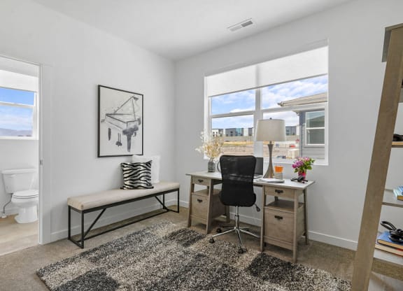 a bedroom with a desk and a window