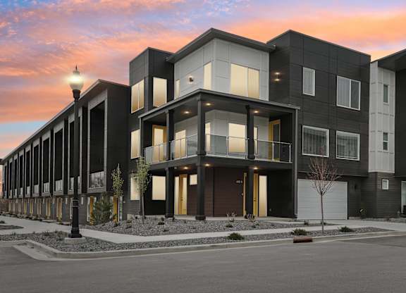A modern apartment building with black and white exterior and yellow accents.