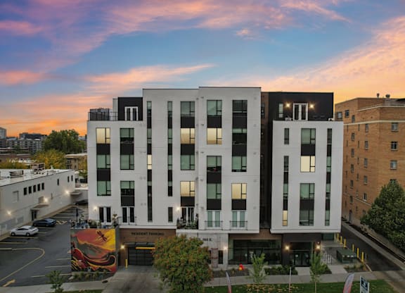 A modern building with a glass entrance and a mural on the wall.
