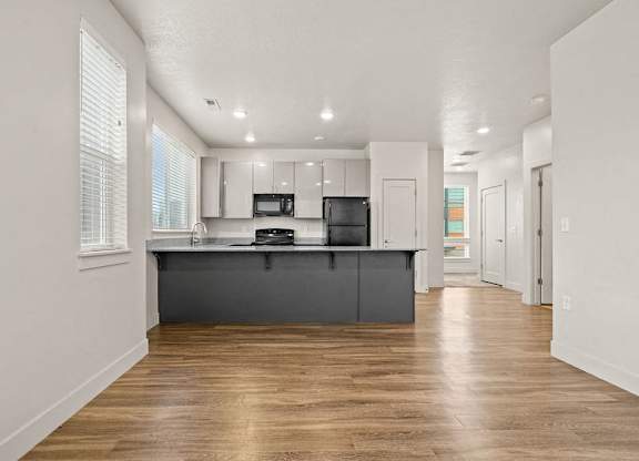 A kitchen with a wooden floor and white walls.