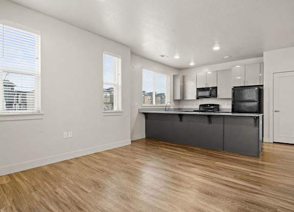 A kitchen with a wooden floor and white walls.