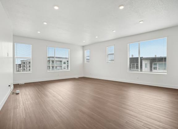 A large empty room with wooden floors and white walls.