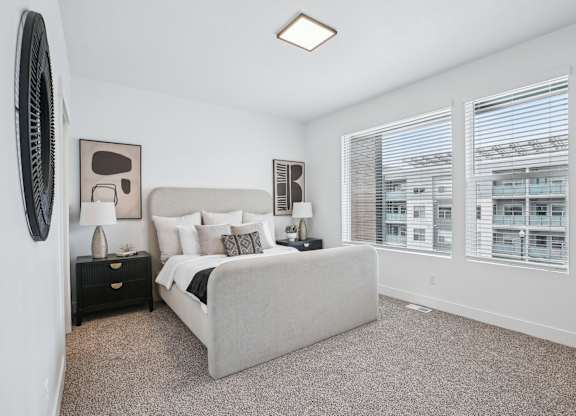 A bedroom with a large bed, a dresser, and a window with blinds.