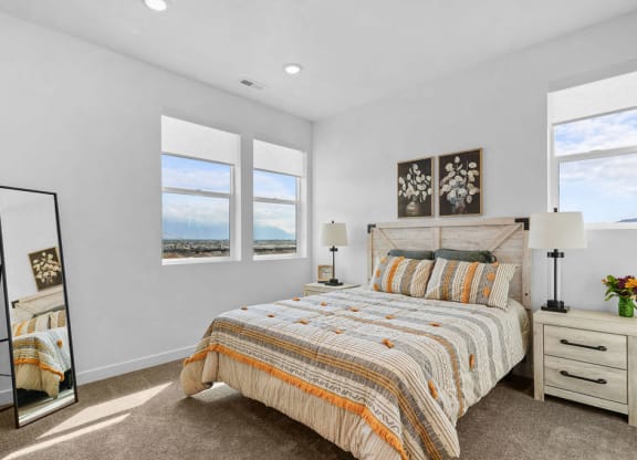 a bedroom with a bed and three windows