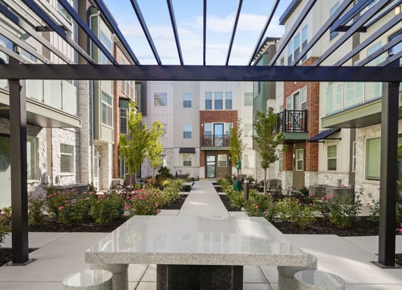 a marble table and stools in a courtyard with buildings