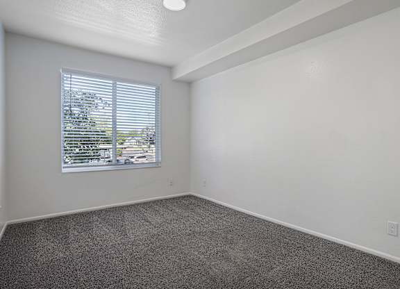 A room with a window and a car parked outside.