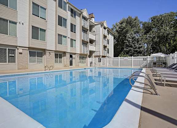 A large swimming pool in front of apartment buildings.