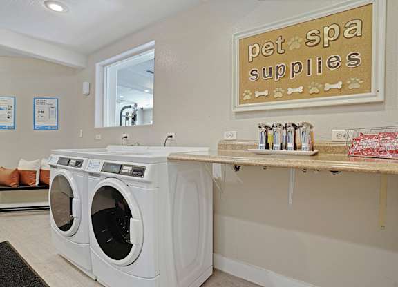 A pet spa supplies sign is on the wall above a counter.