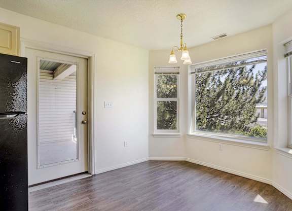 A room with a door, a window, and a chandelier.