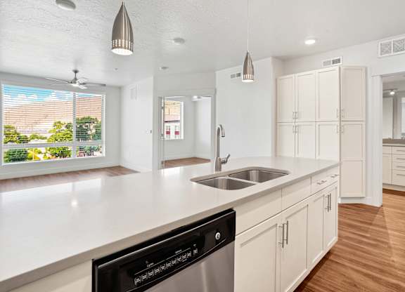 a kitchen with white cabinets and a large window