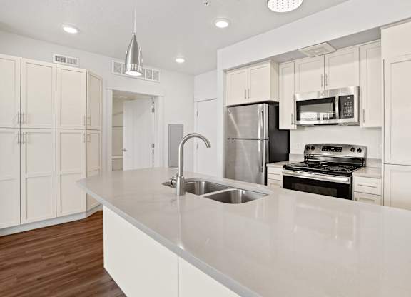 a kitchen with white cabinets and a large island