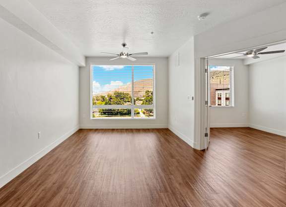 a bedroom with hardwood floors and a large window