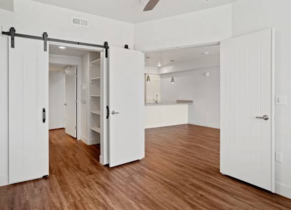 a bedroom with a medium hardwood floor and white walls