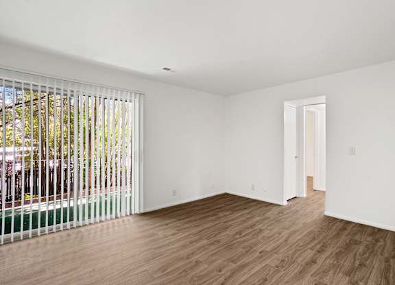 a bedroom with hardwood floors and white walls
