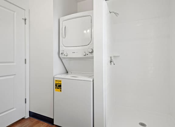 a white washer and dryer in a room with a white door